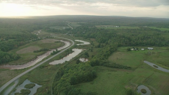 空中的河流通过农村地区。森林中的树林中的树农田。视频素材