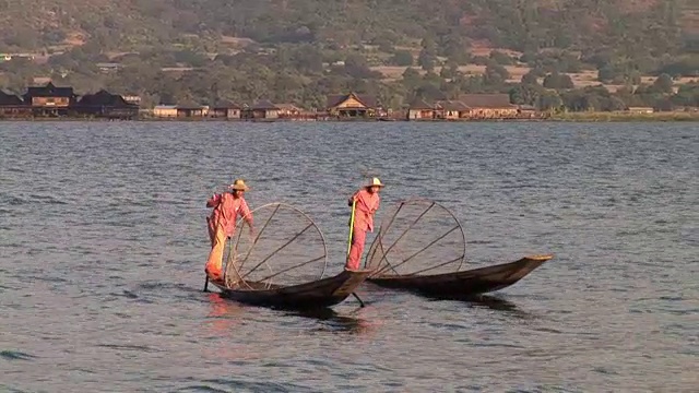 两个渔民用他的腿划着船视频素材