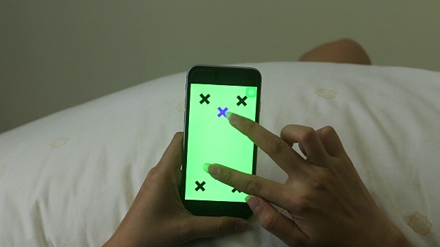 女人的手握着智能手机的绿色屏幕的特写，预设的效果视频素材