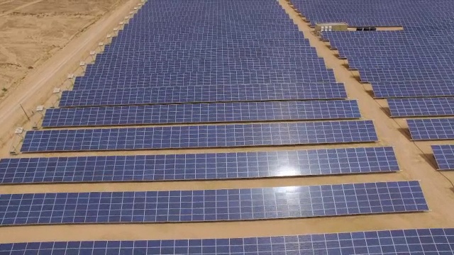 鸟瞰图的太阳能阵列在沙漠与太阳反射板视频下载
