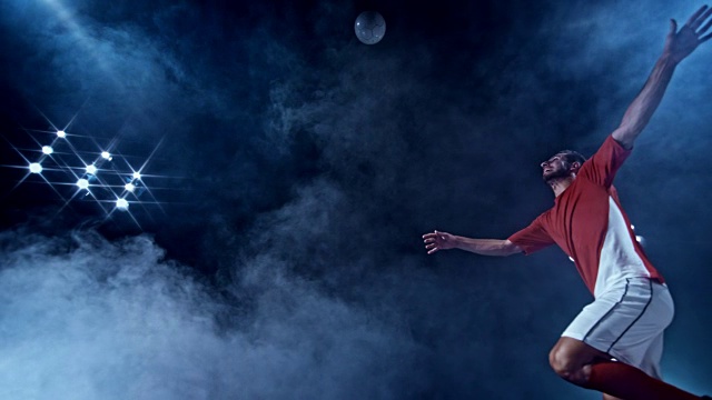 SLO MO LD男性足球运动员在一个黑色雾蒙蒙的背景下用剪刀式踢向空中视频素材
