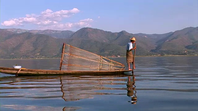 渔夫用腿划小船视频素材