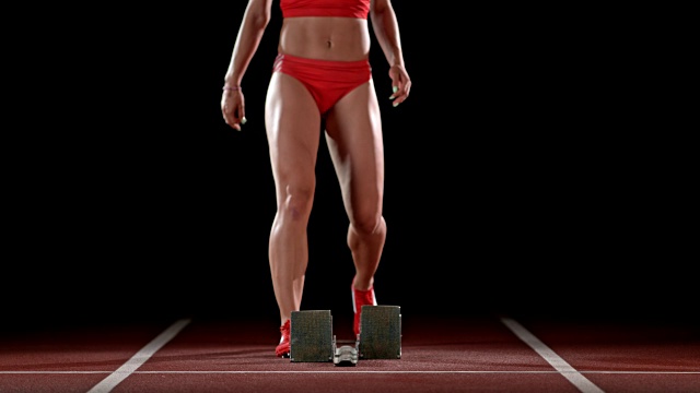 SLO MO LD女子短跑运动员在起跑线上取得她的位置视频素材