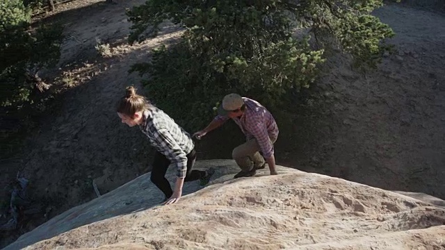 一对二十多岁的情侣在岩石悬崖上散步视频素材