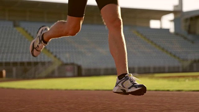 SLO MO DS TU白人男运动员在阳光明媚的体育场里跑步视频素材