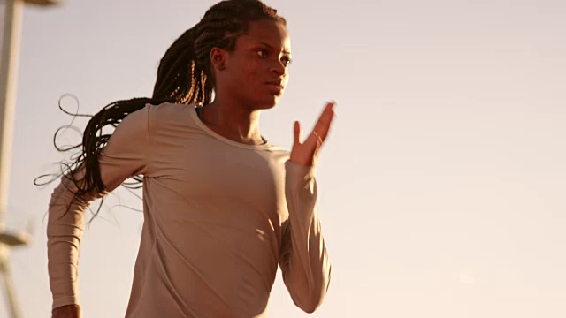 SLO MO DS女非洲裔美国运动员，在日落时在体育场梳着长长的辫子视频下载