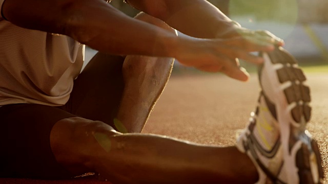 日落时分，非裔美国人在体育场做伸展运动视频素材