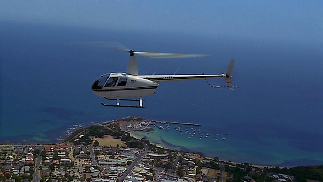 宽镜头跟踪拍摄直升机飞过莫宁顿半岛/澳大利亚视频素材