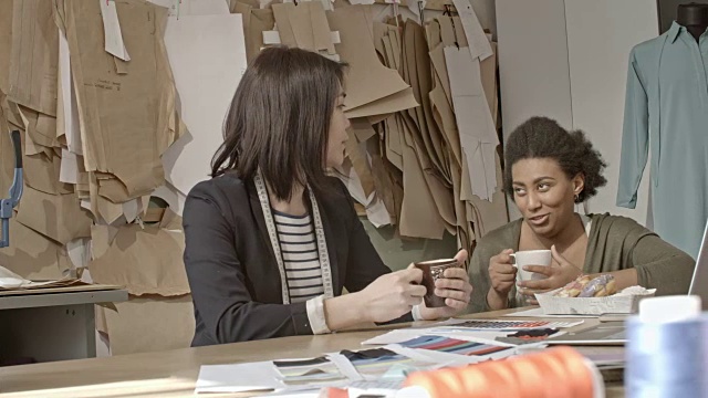 女裁缝在缝纫车间聊天喝茶视频素材
