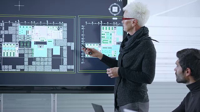 资深女性白种建筑师在会议室使用大屏幕展示项目计划视频下载