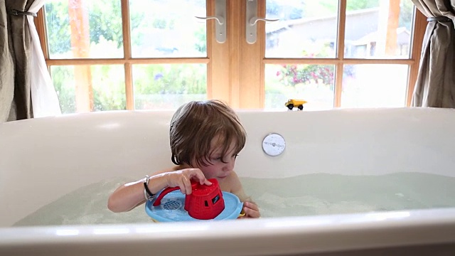 3岁男孩在浴缸里玩视频素材