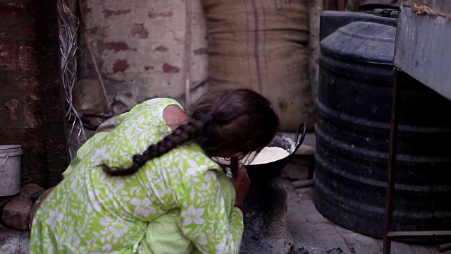 妇女在泥炉上做饭视频素材