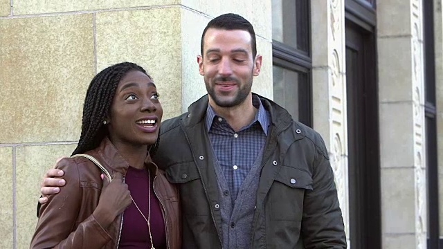 年轻的跨种族情侣在城市里站在一起视频下载
