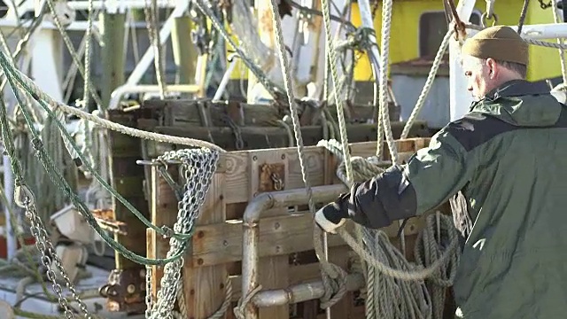在商业渔船上卷绕绳索的工人视频下载