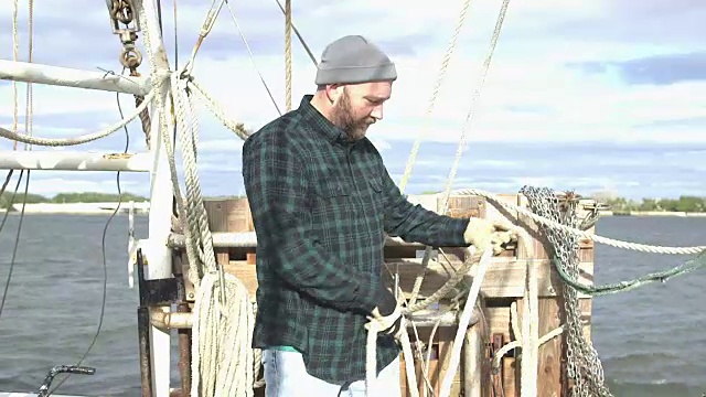 在商业渔船上卷绕绳索的工人视频下载