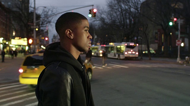 一个年轻人晚上穿过纽约大街视频下载