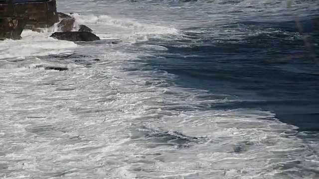 在印尼巴厘岛的黑沙滩上，海浪拍打着沙滩视频素材