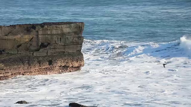 高清:来自太平洋的海浪在印尼巴厘岛海滩上撞击悬崖视频素材