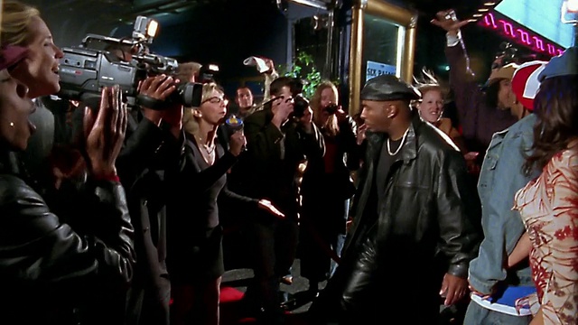 慢动作中镜头跟踪镜头嘻哈夫妇走在红地毯之间的一排歌迷和媒体视频下载