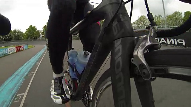 可穿戴相机序列显示的框架碳纤维自行车正在使用的一个男性自行车在室内赛车场，伦敦，英国。视频下载