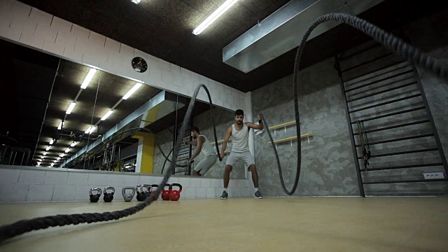 运动黑人男子在体育馆里做格斗绳练习的慢动作。视频素材