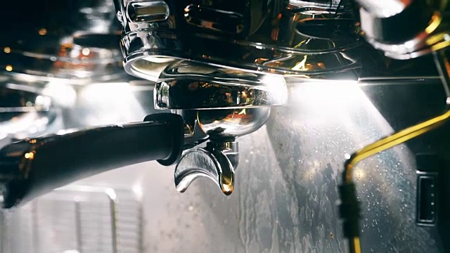 咖啡师把咖啡从机器滴到杯子里。视频素材