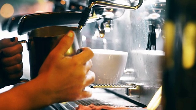 咖啡师用咖啡机热牛奶。视频素材