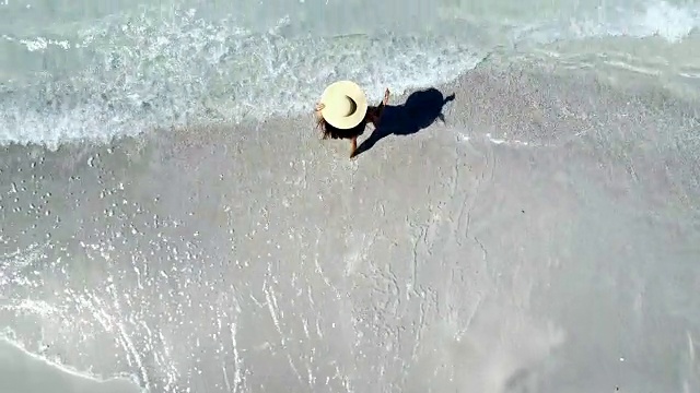 女人走在海滩上-无人机的观点视频下载