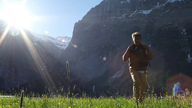 日出时，男性徒步者穿过高山草甸，高山视频素材