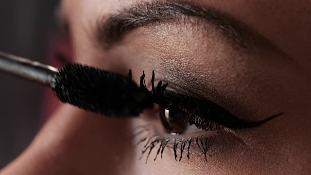 一个女人在睫毛上涂睫毛膏的极端特写。视频下载
