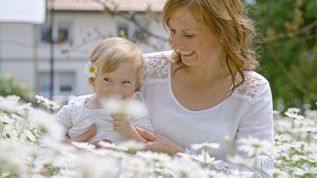母亲和她可爱的小女儿在雏菊中玩耍视频素材