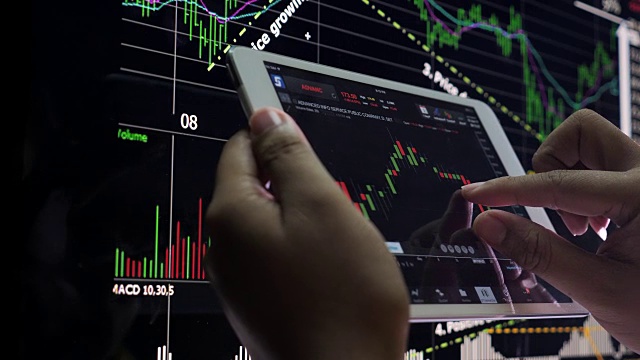商人在智能手机和电脑上分析股票市场数据视频下载