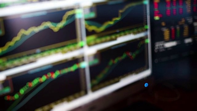 股票经纪人在LED显示屏上监控股票市场图表。视频素材
