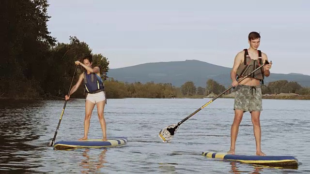 年轻男女在SUP上划桨视频素材