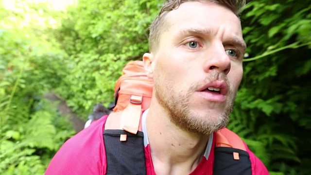 一个男人背包穿越森林的特写镜头视频素材