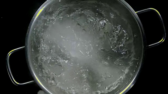 一小撮盐溅入沸腾的锅中视频素材