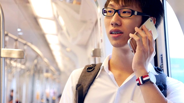 一名年轻人在火车上使用手机视频下载