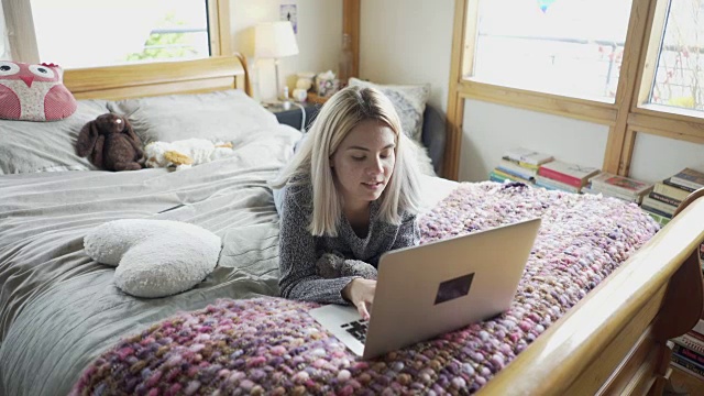 一个十几岁的女孩用她的笔记本电脑与外界交流。视频下载