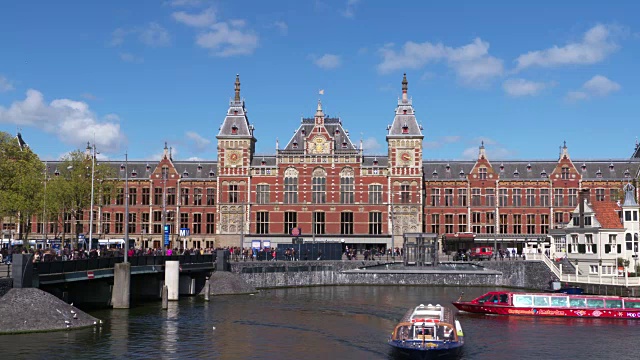 阿姆斯特丹中央车站和运河上的船只。荷兰北荷兰的阿姆斯特丹视频素材