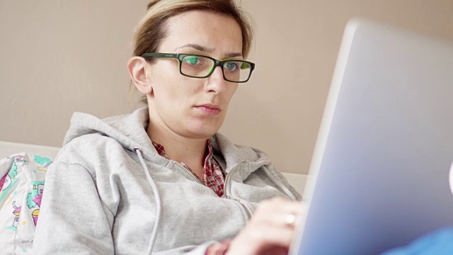 年轻女子在家用笔记本电脑工作视频下载