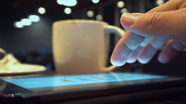 使用平板电脑和喝咖啡在咖啡馆，特写视频素材