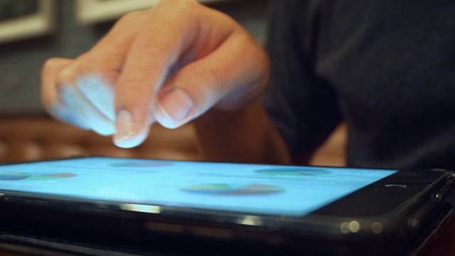 男人使用平板电脑和喝咖啡在咖啡馆，特写视频素材