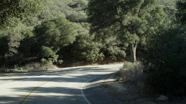 一辆右向左的油罐车行驶在农村地区的乡村公路上。视频下载
