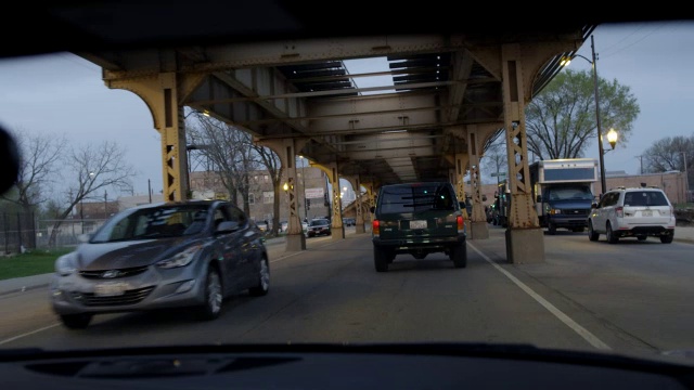 广角驾驶pov直行跟随越野车，接近碰撞。城市街道在高架铁轨下。可能是汽车追逐的一部分。视频素材
