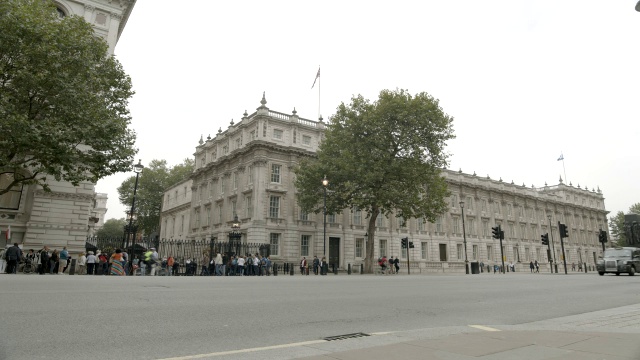唐宁街10号和政府大楼入口的广角。白厅SW1。行人和游客随处可见。妇女二战纪念碑或纪念物部分可见。视频下载