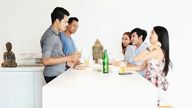 一群亚洲朋友在厨房聚会上聊天视频下载