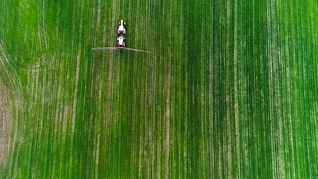农业。农用拖拉机喷洒农田俯视图。视频下载