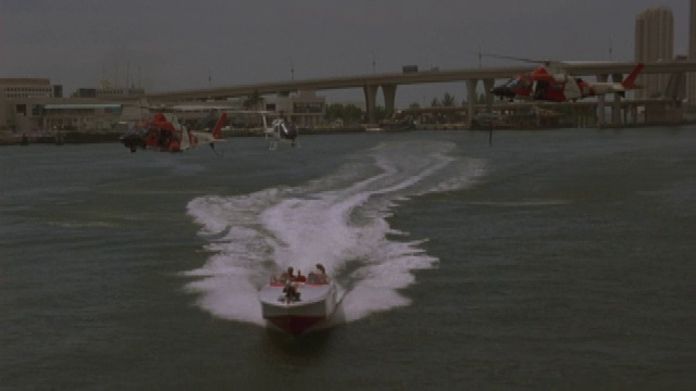 三架直升机在迈阿密附近追赶一艘汽艇。视频素材