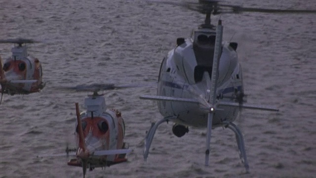 三架直升机从水面上飞到岸边。视频素材