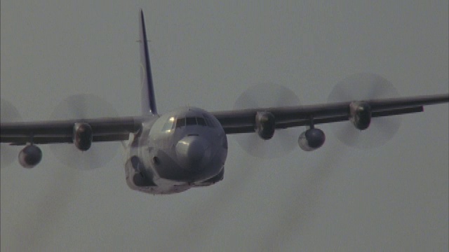 一架C-130大力神运输机飞过一片朦胧的天空。视频素材